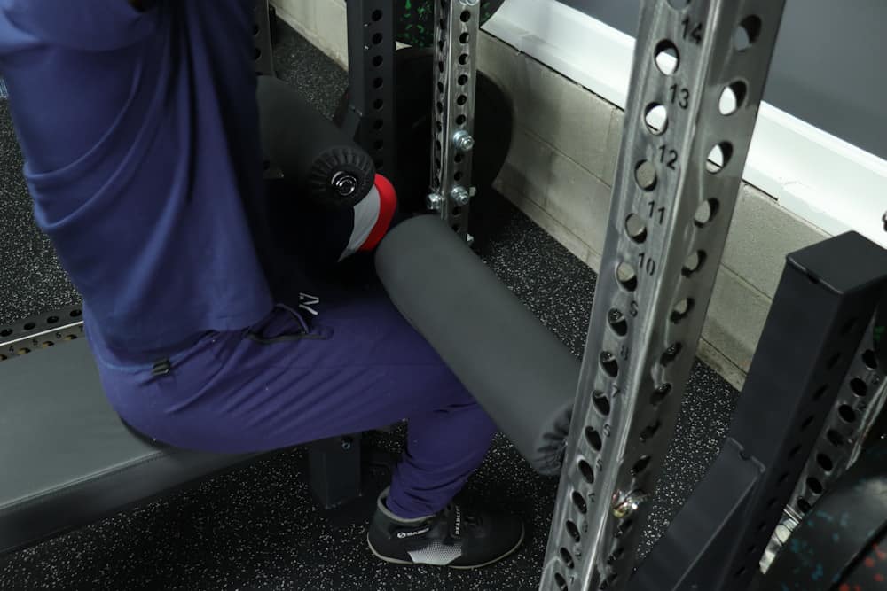 Using a Pair of REP Leg Rollers to Hold Legs in Place for Lat Pulldowns